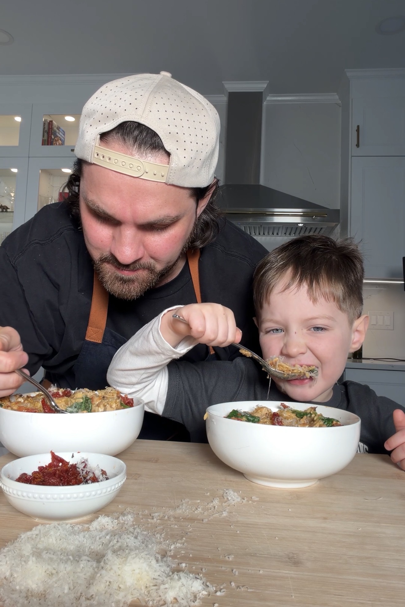 dad and son eating creamy chicken orzo at dinner